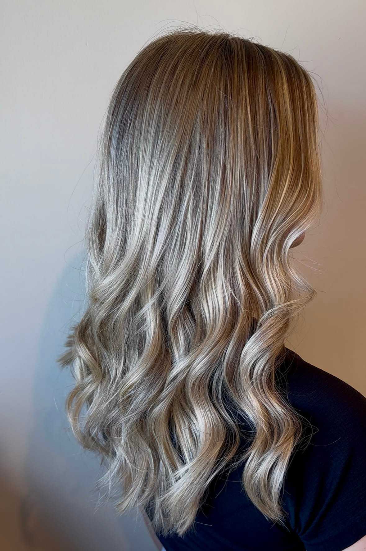 Wavy blonde hair with natural highlights against a plain background.